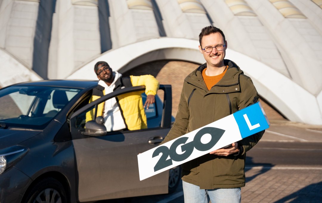 Jugendlicher und Fahrbuddy von 2GO Lokeren am Fahrschulwagen